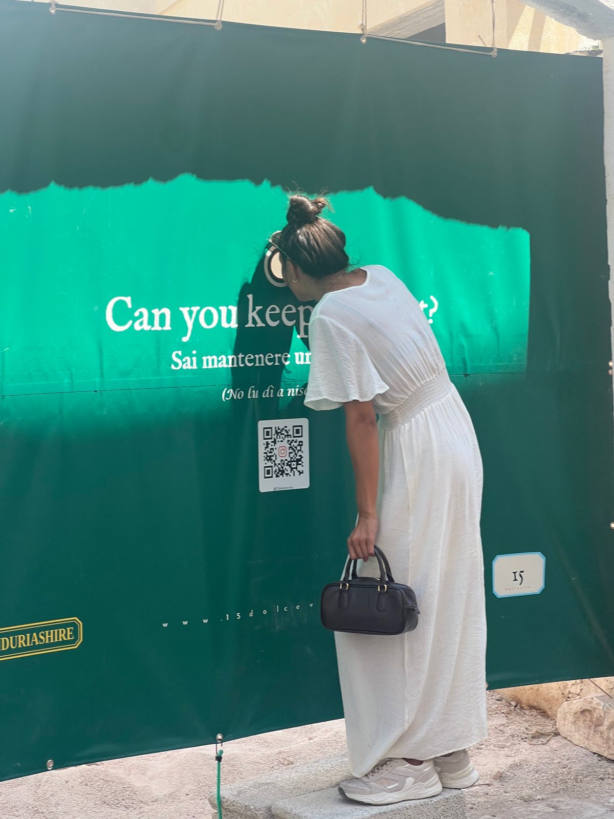 Green tarpaulin with a question on the gate of Via Verdi 15, Manduria